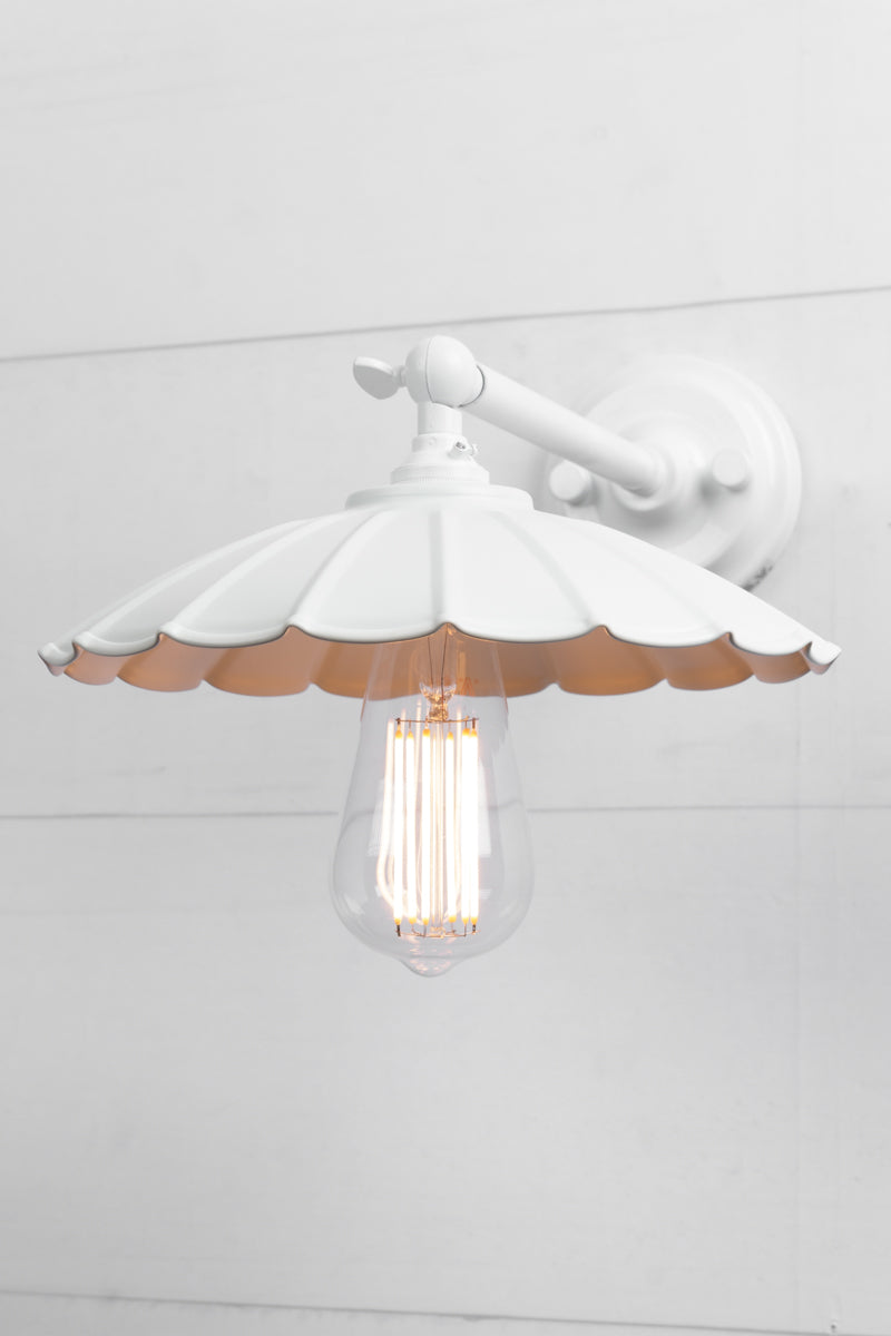 Small white umbrella shade on a white wall sconce. 