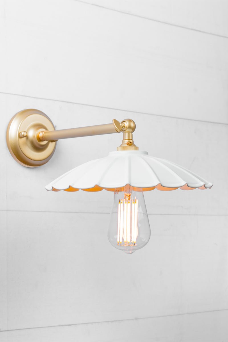 Small white umbrella shade on a gold/brass wall sconce. 