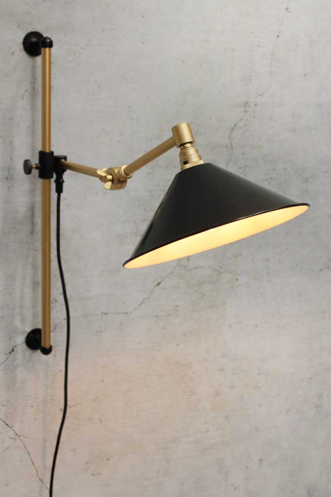 Gold/brass arm wall sconce with black small shade