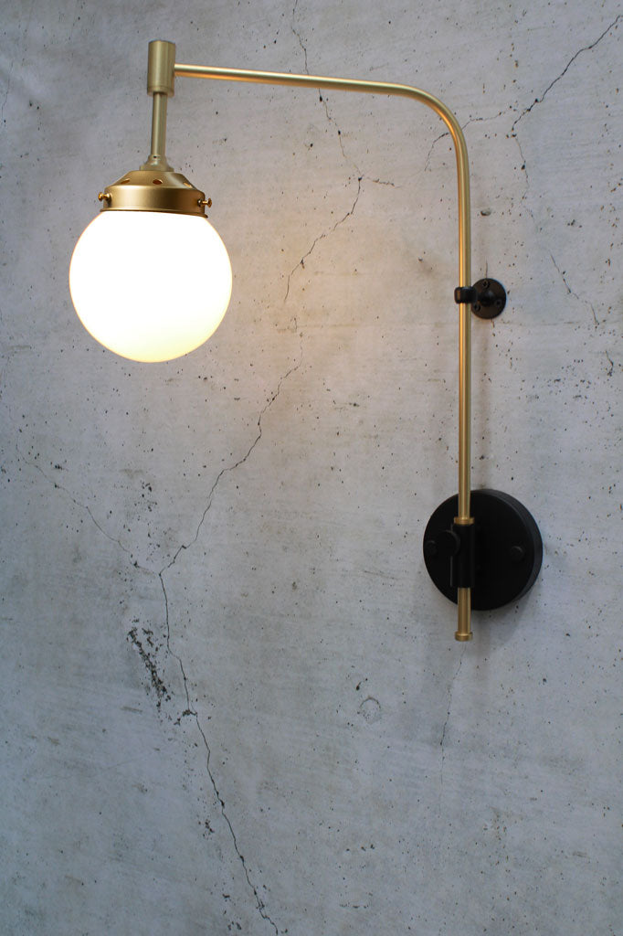 Gold/Brass swing wall arm with opal glass ball shade. 