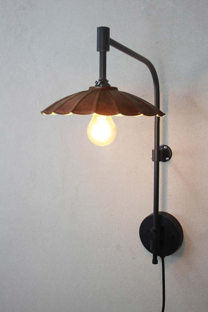 Black wing arm with wall plug and a small rust coloured umbrella shade