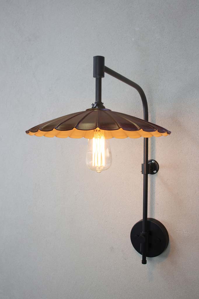 Black wing arm with a large rust coloured umbrella shade