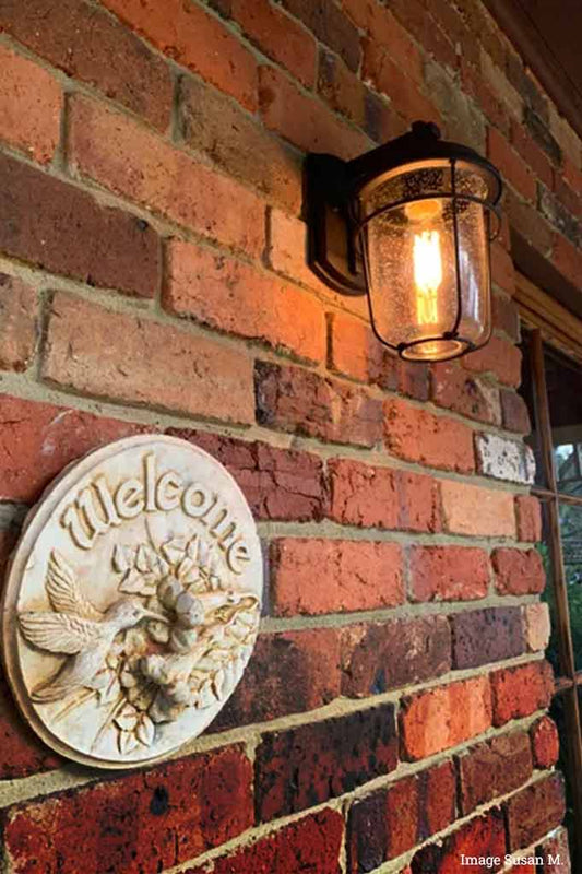 Small black steel outdoor wall light in a front porch