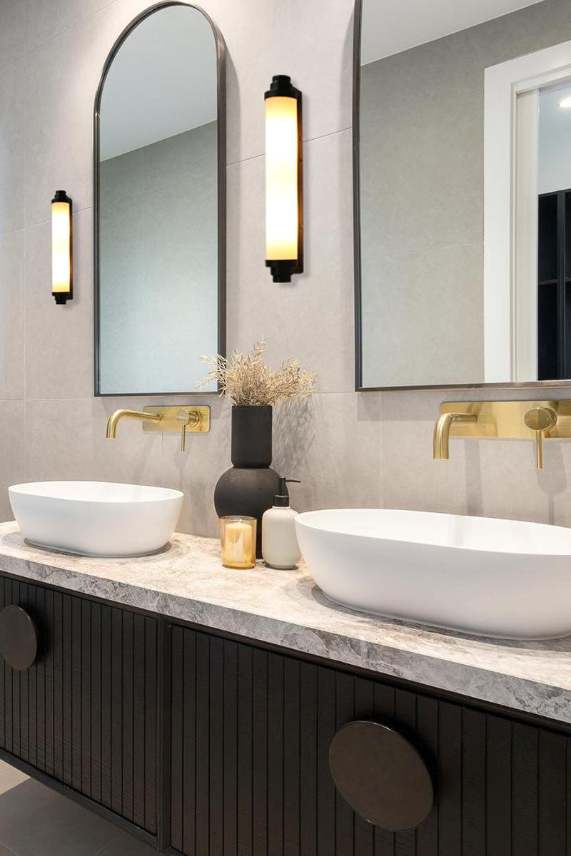 Two black tate wall lighs in a modern bathroom either side of the mirrors. 