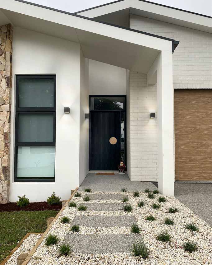 Two square concrete wall sconces hanging either side of a modern mid-century home entrance.