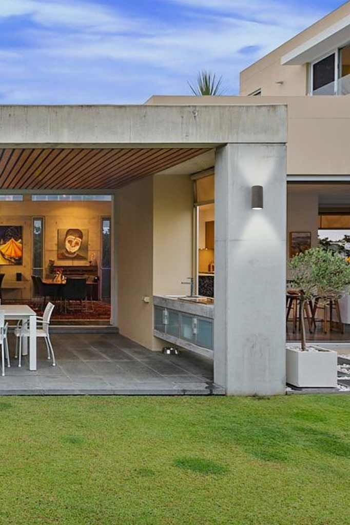 Black sandstone outdoor wall light in the backyard of a house.