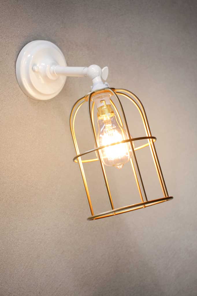 Cage Wall Light with short white sconce and gold/brass caged shade.