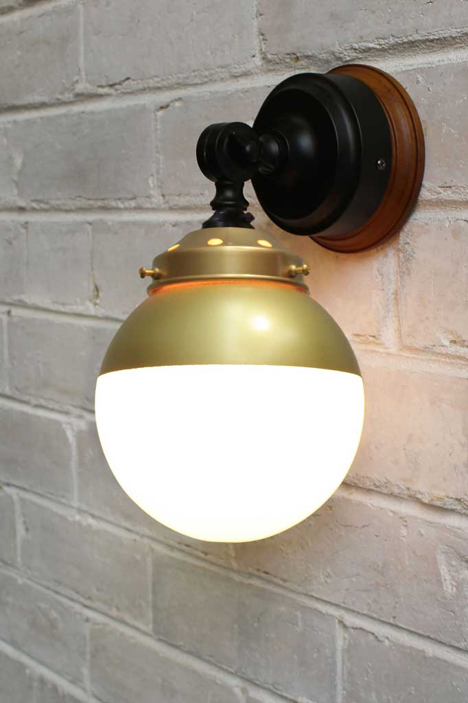 Crown Sphere Swivel Arm Wall Light with a black mounting arm, gold gallery and a gold and opal shade