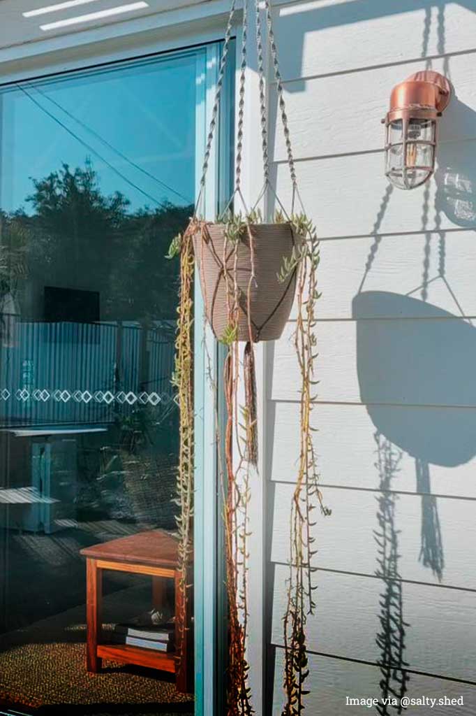 cage wall light in copper finish in the backyard of a house