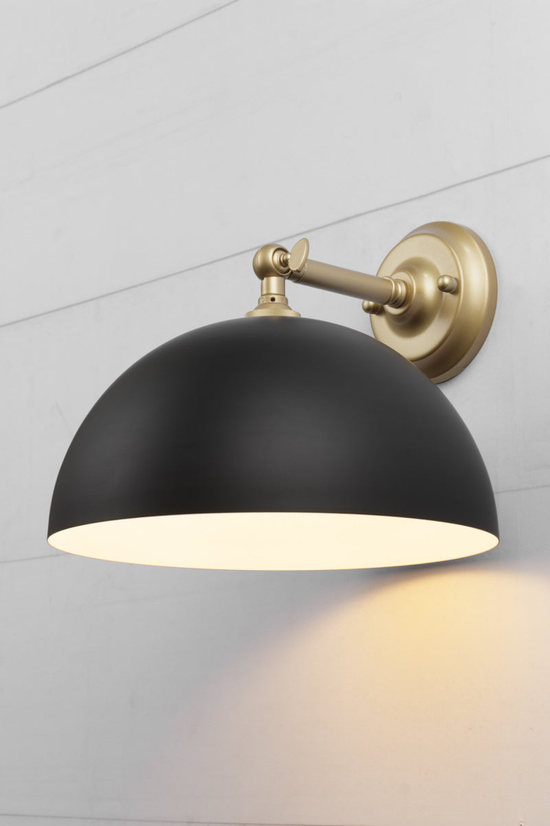 Small black dome shade on a steel gold/brass straight arm wall sconce