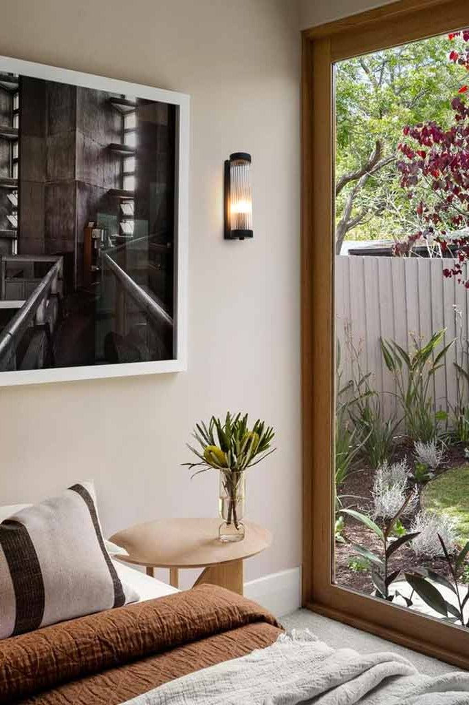 glass rod wall light in black finish in a bedroom