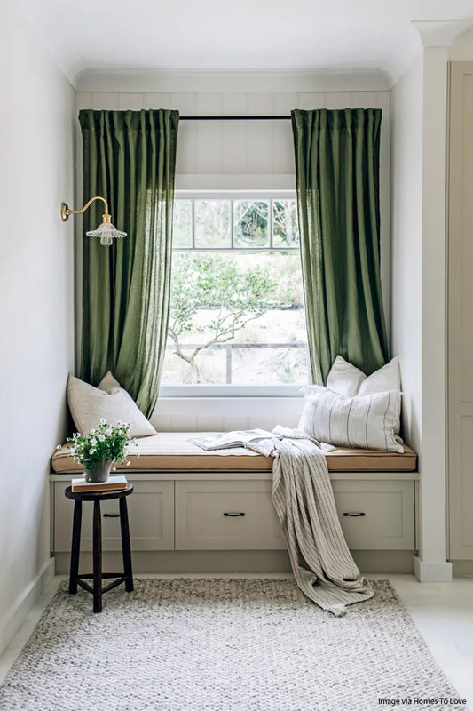 Gold/brass gooseneck wall sconce with glass frill shade in a seating area. images Via Homes to Love. 