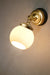 Small open ended opal glass ball shade on a gold/brass wall sconce