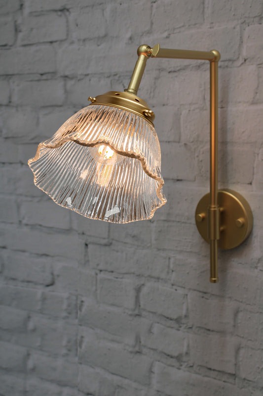 Gold/brass wall sconce with ribbed frill edged shade. 