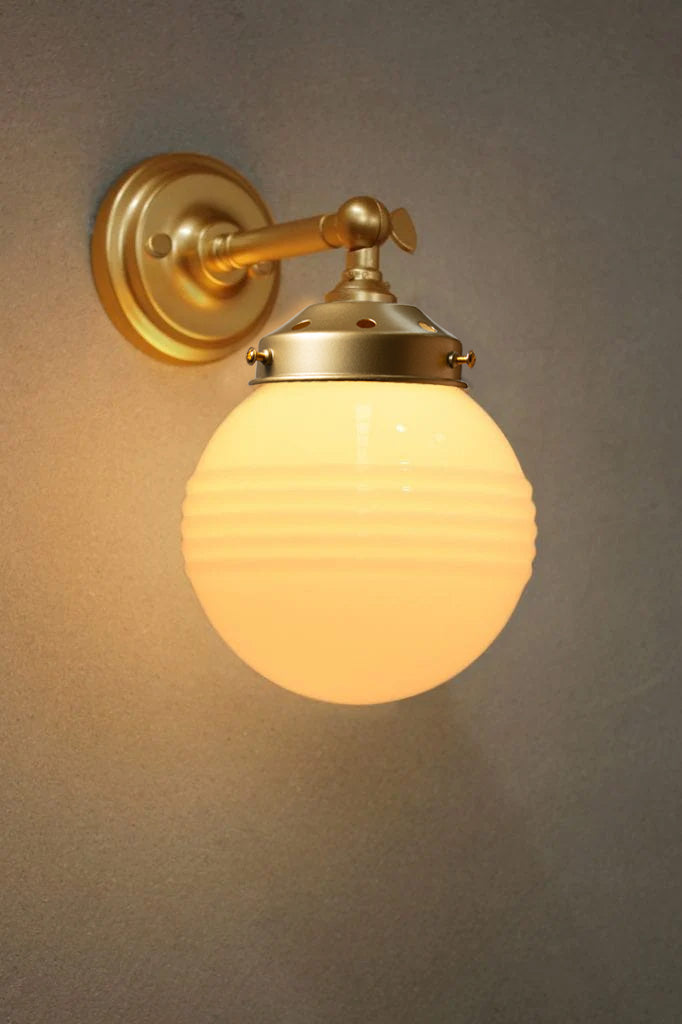 Opal ridged glass ball shade on a gold/brass wall sconce