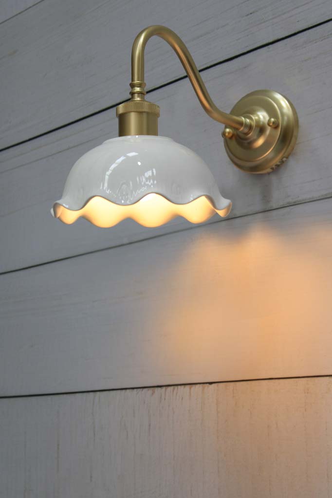 Wall lamp with gold/brass gooseneck arm affixed on wall.