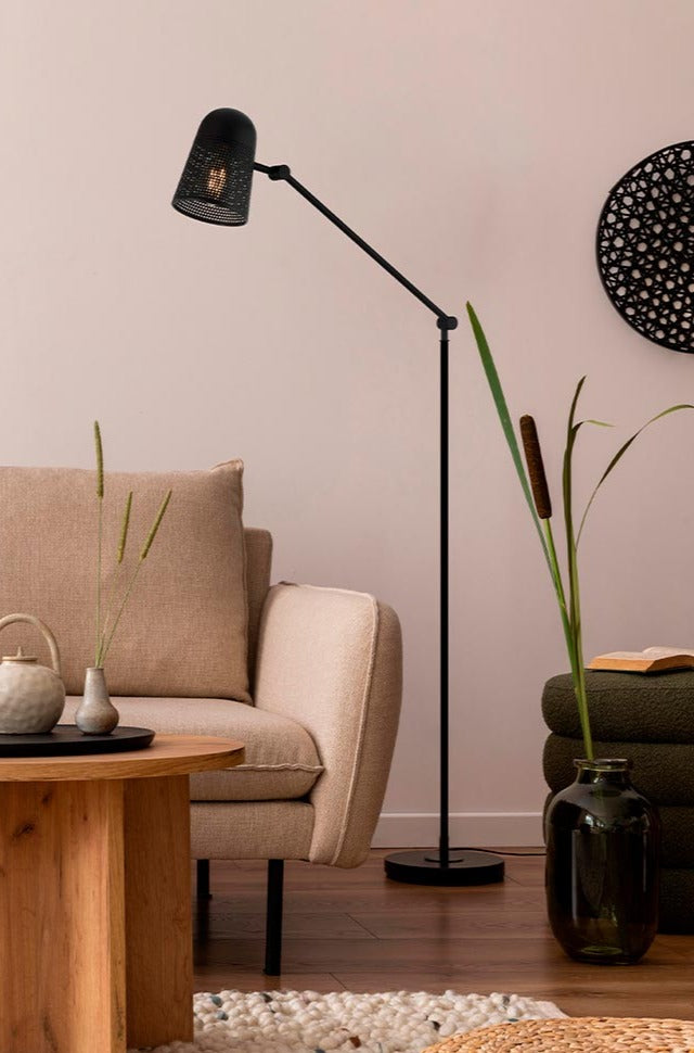 Modern black Cadena Floor Lamp illuminating a cozy living room corner.