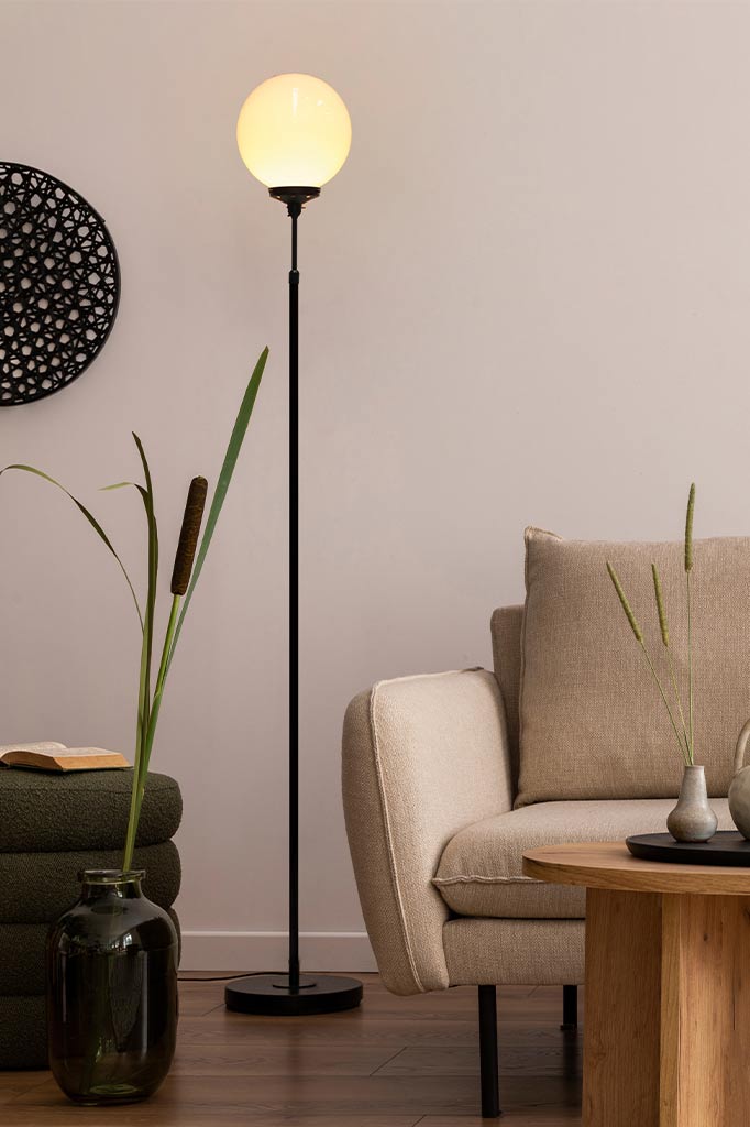 floor lamp with opal glass ball shade in a living room.