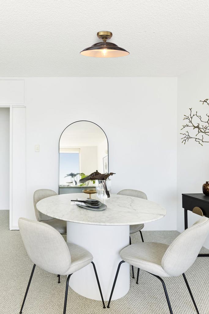 Barn Close To Ceiling Light with black shade and gold/brass batten holder in a dining area.