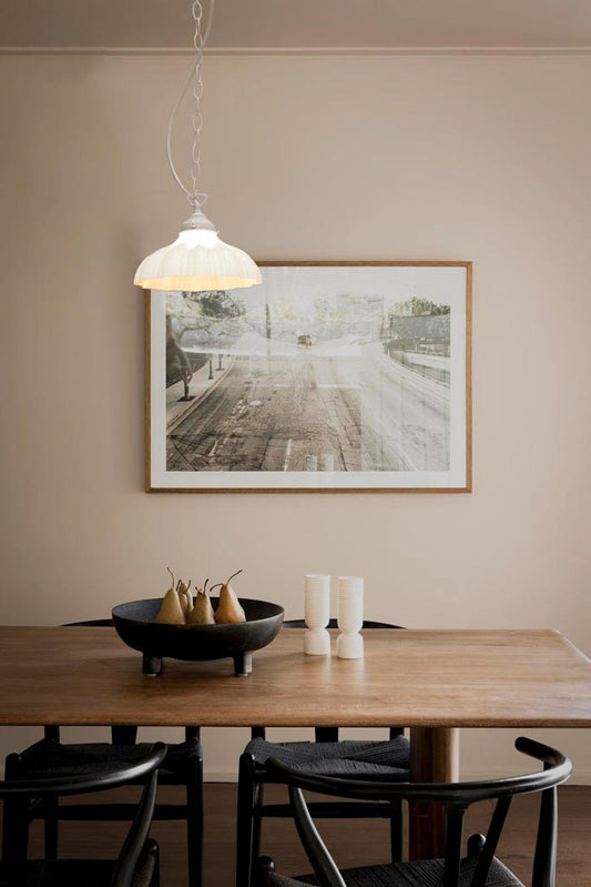 small shade on white chain over dining room