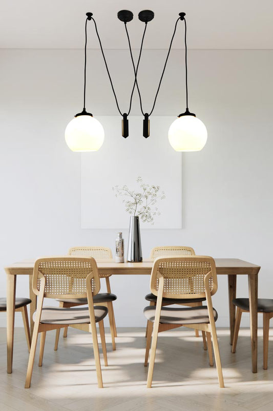 medium round open glass shade with pulley suspension cord over dining table.