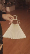 Table lamp with a pleated shade placed - video on how to put it on