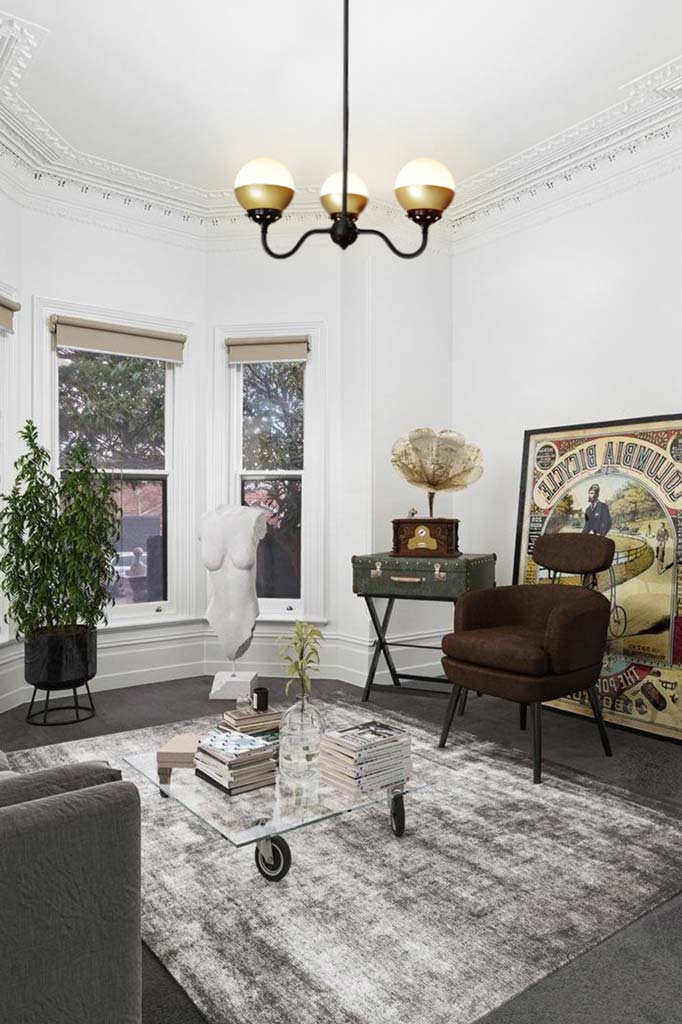 Pendant light with opal glass shades on three upright gooseneck arms hung from a ceiling 