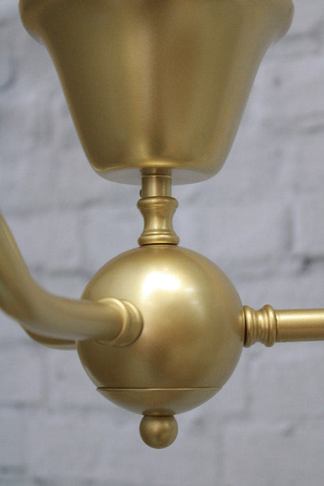 Gooseneck flush mount light in gold close up on centrepiece