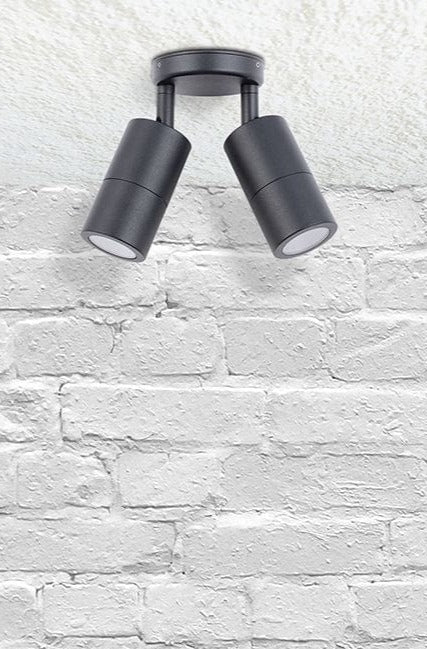 Twinlight spotlight in black affixed on a brick wall.