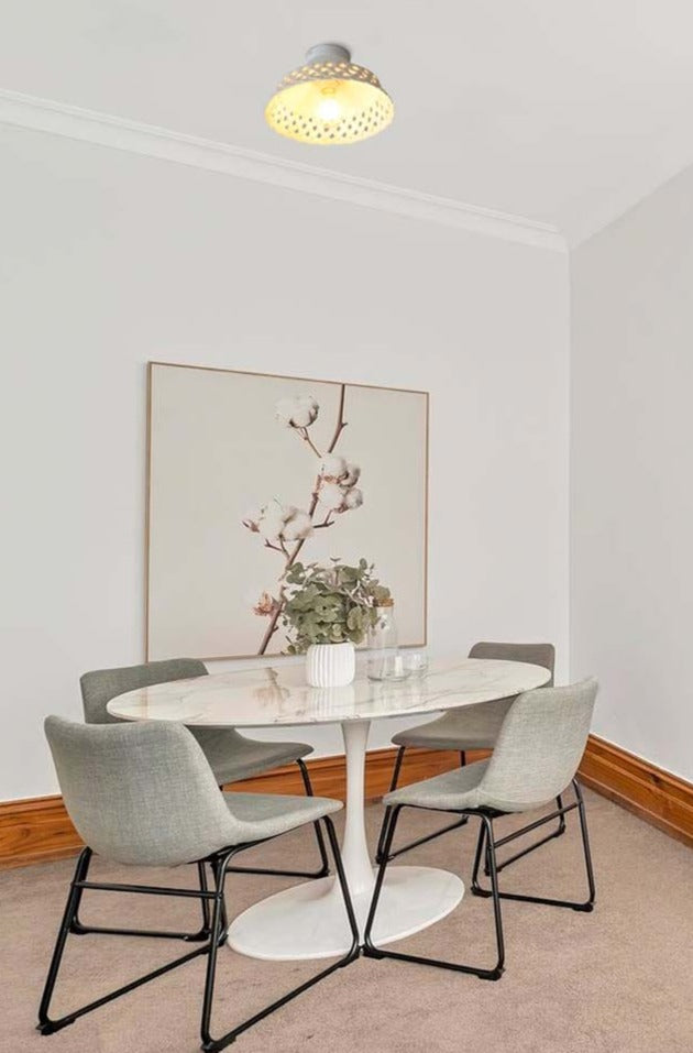 Ceramic flush mount shade over dining table.