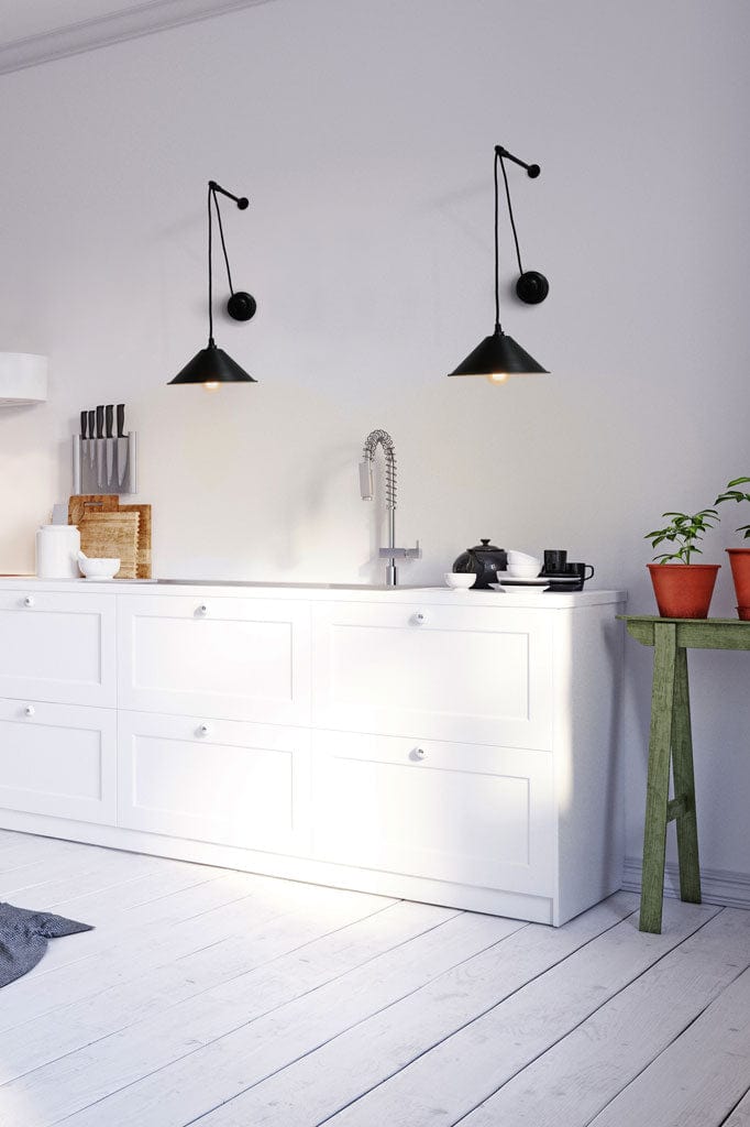 A pair of black cone pulley wall lights hung above dresser. 