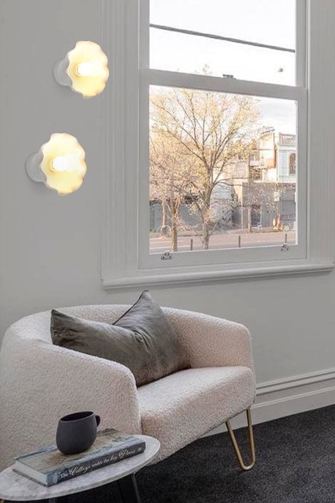 Two ceramic wall mounts mounted above a chair within a living room setting. 