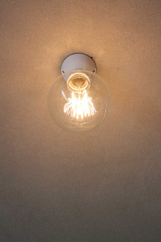 Ceramic flush mount light with bare bulb