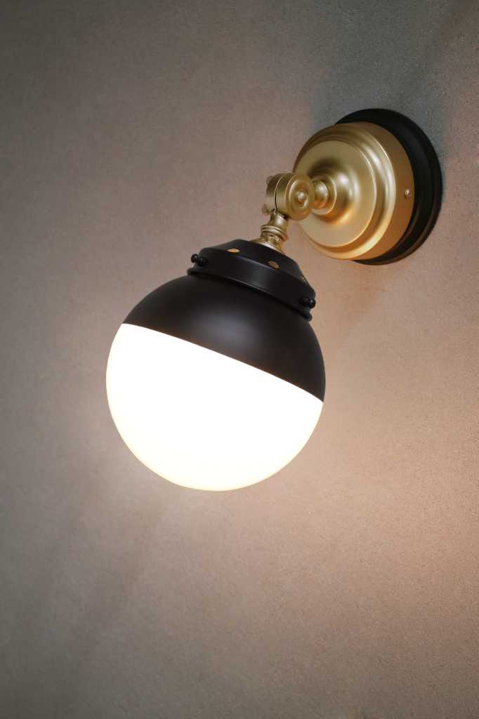 Crown Sphere Swivel Arm Wall Light with a gold mount arm, black gallery and a black and opal shade