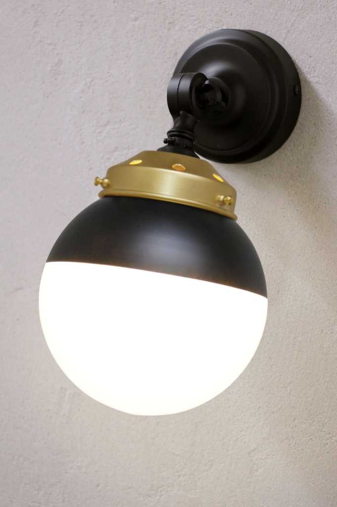 Crown Sphere Swivel Arm Wall Light with a black mounting arm, gold gallery and a black and opal shade