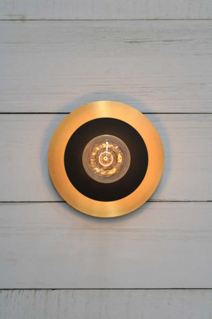 Large brass with small black disc wall light