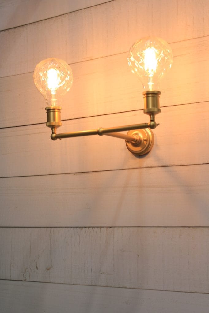 Double arm wall sconce in gold