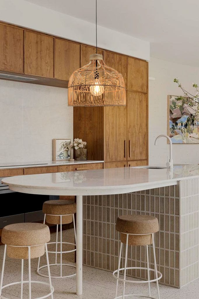 Rattan bell shaped pendant hanging over kitchen bench