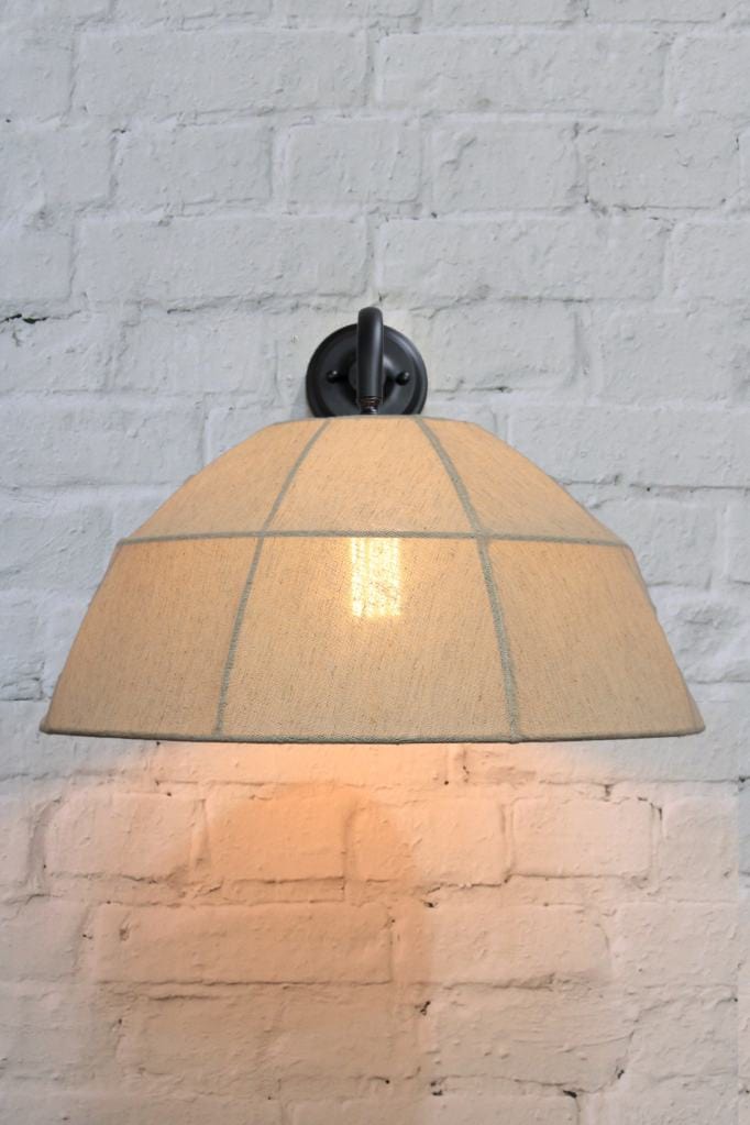 Black wall light with natural linen shade