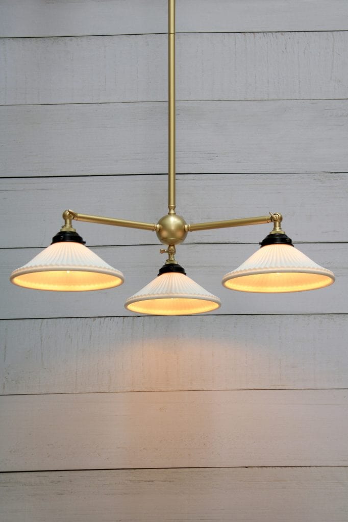 Three light chandelier in gold/brass finish with ceramic shades