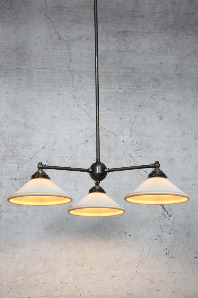 Three light chandelier in antique bronze finish with three ceramic shades