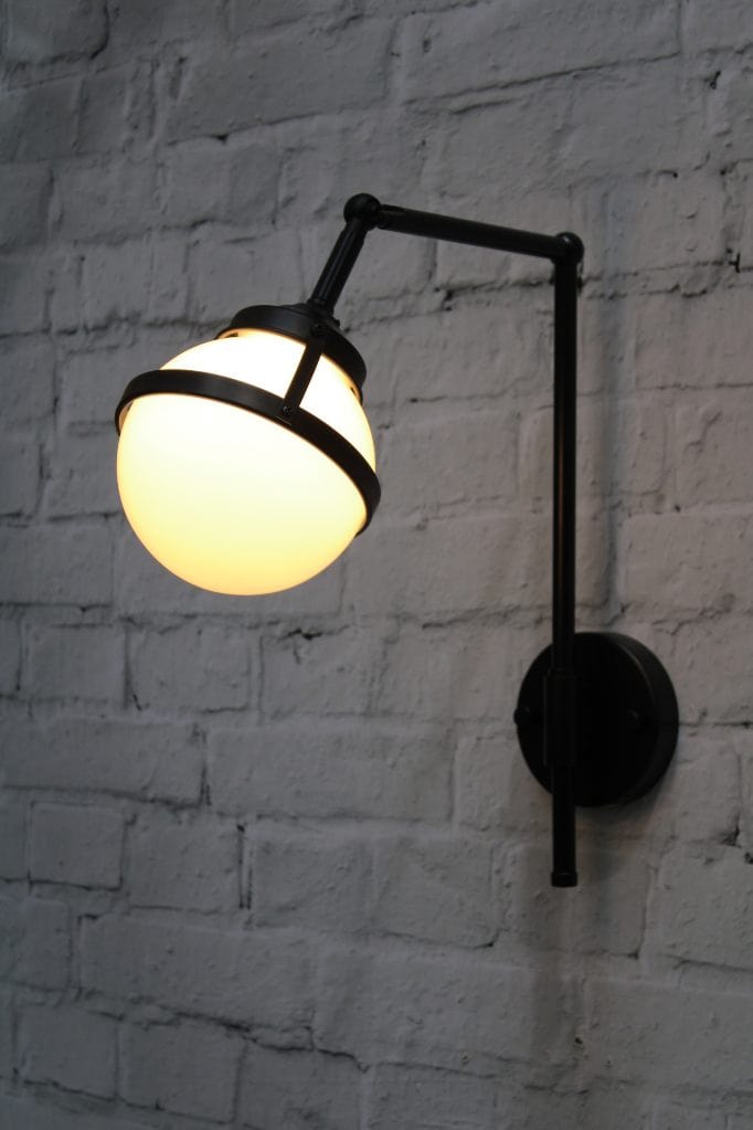 Wall light with black swivel arm and opal glass ball shade with metal band