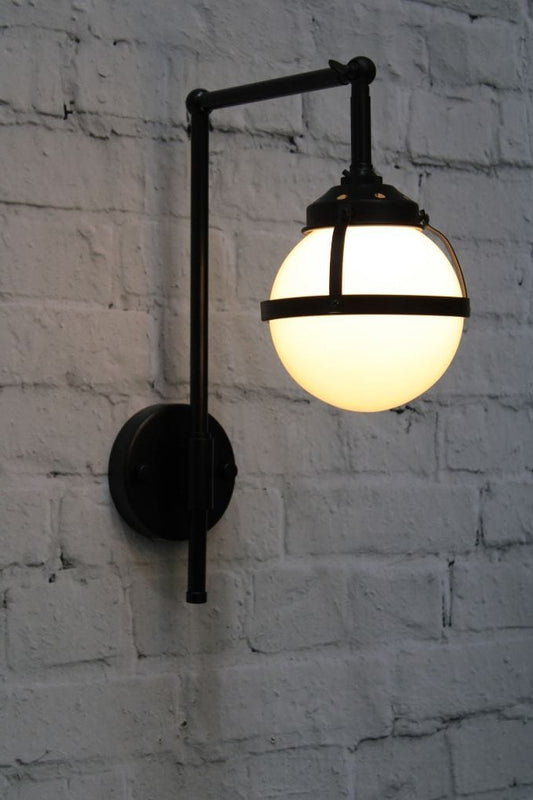 Wall light with black swivel arm and opal glass ball shade with metal band