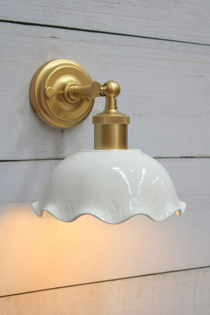 Close-up view of wall light with gold short arm. 