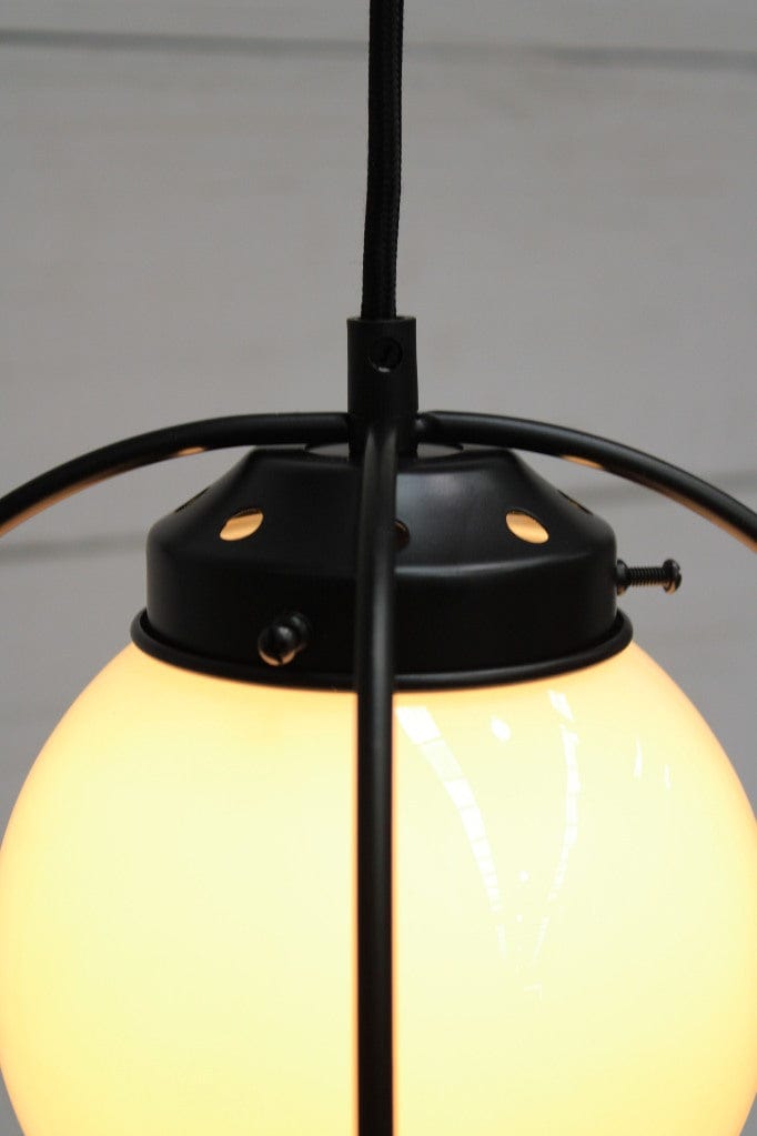 Closeup of black metalware and opal glass ball shade