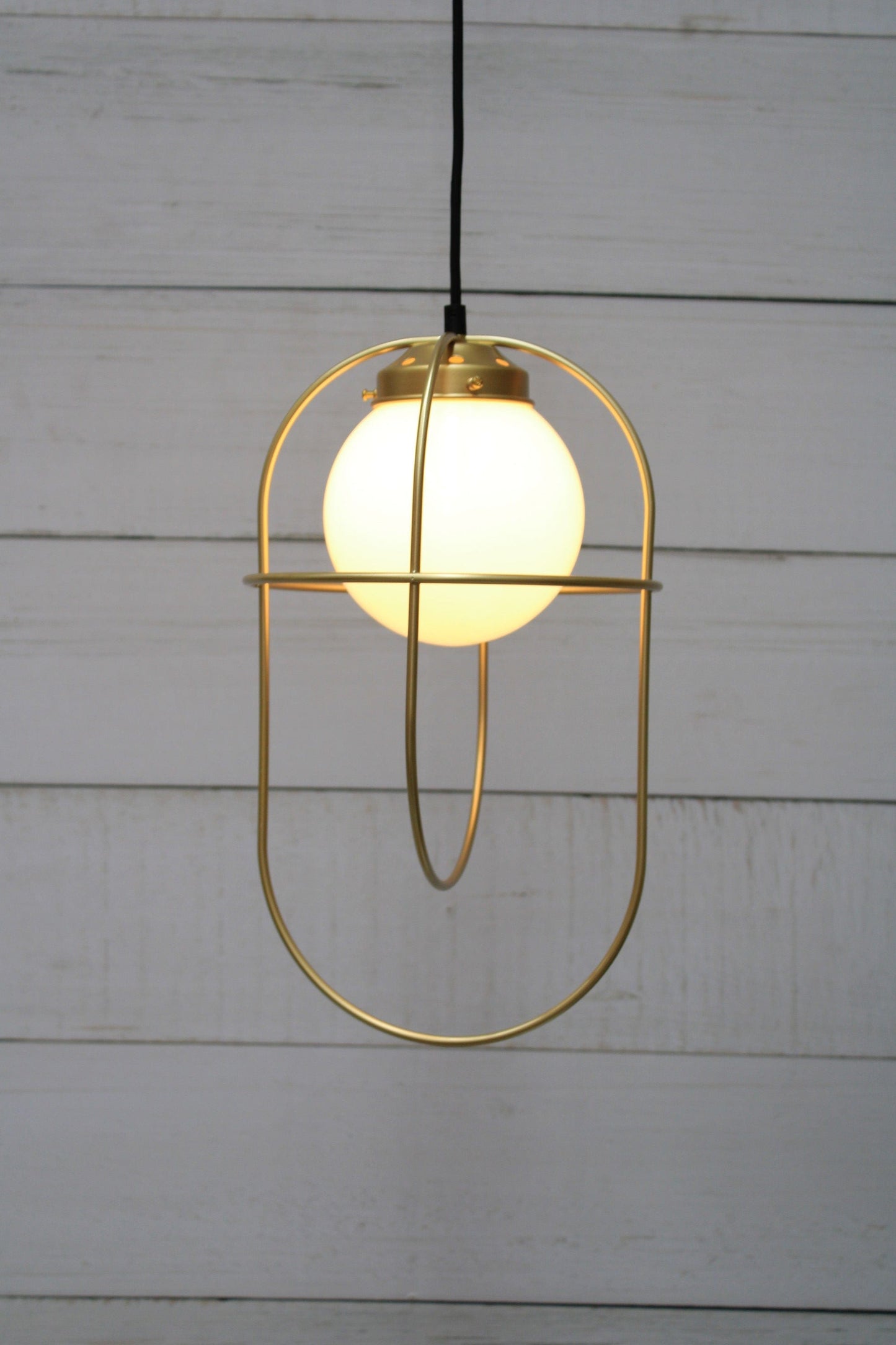 Pendant light with opal glass ball shade and gold/brass metalware.