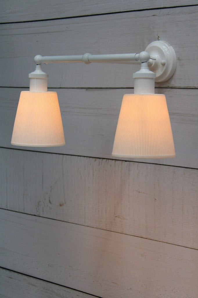 Large ceramic shade affixed on white double swivel arm. 