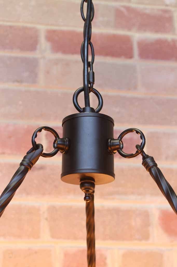 Lodge chandelier has a centerpiece that holds the 3 tisted metal rods to the chain suspension