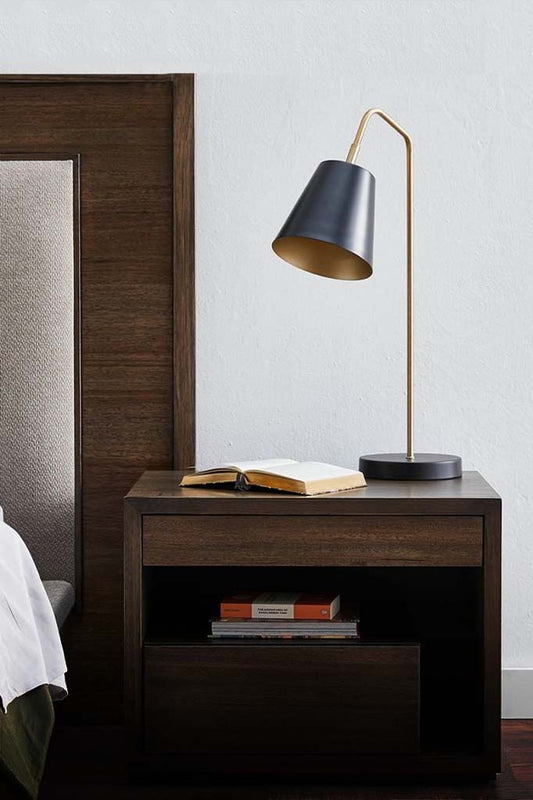 Matt black table lamp over bedside table.