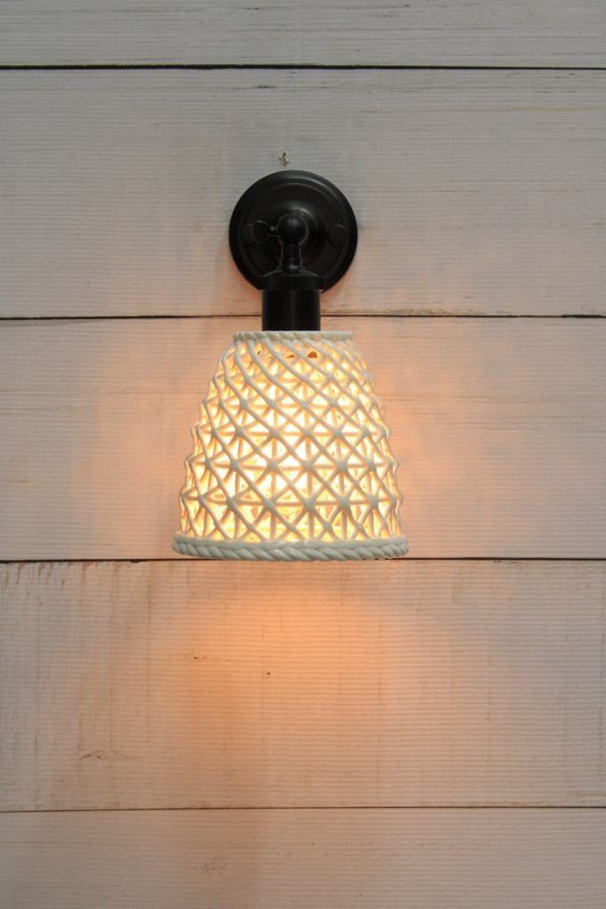 Black wall light with tall ceramic shade